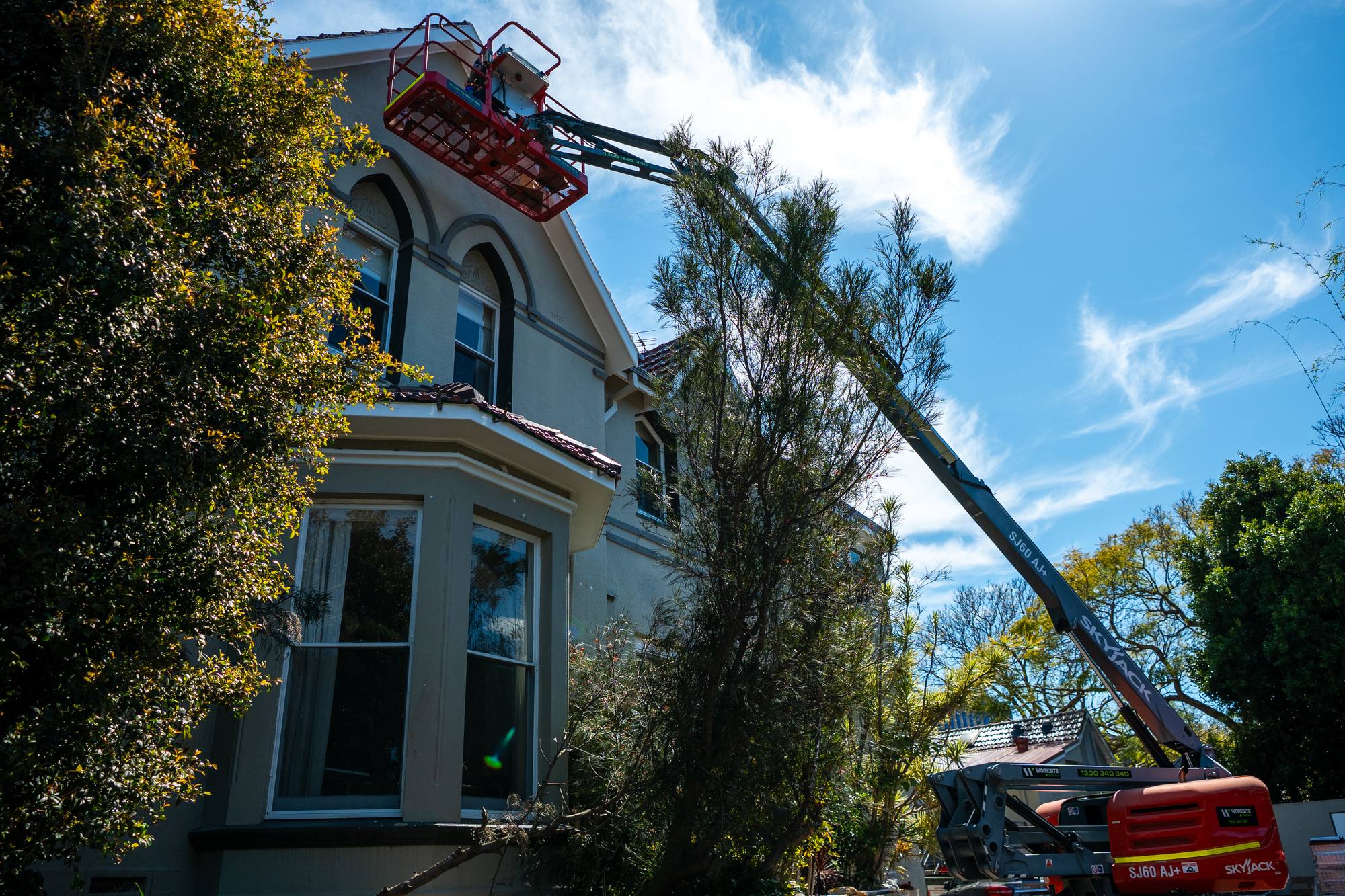 ADKO roofers working from an elevated platform on a Sydney home