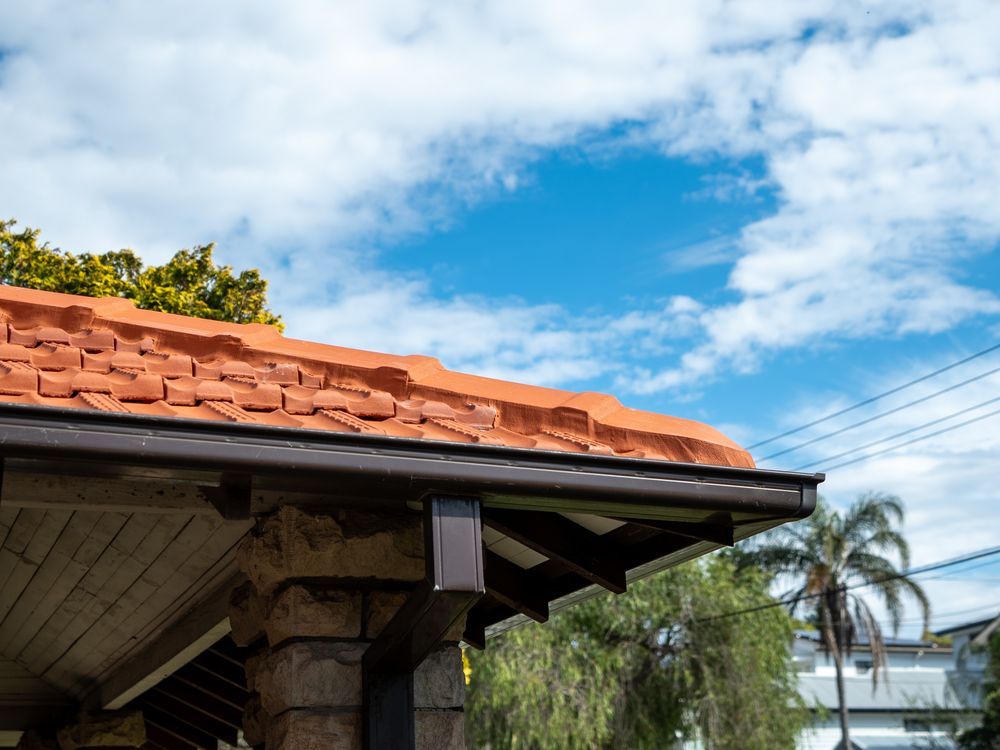 New gutter and downpipe under a terracotta tile roof