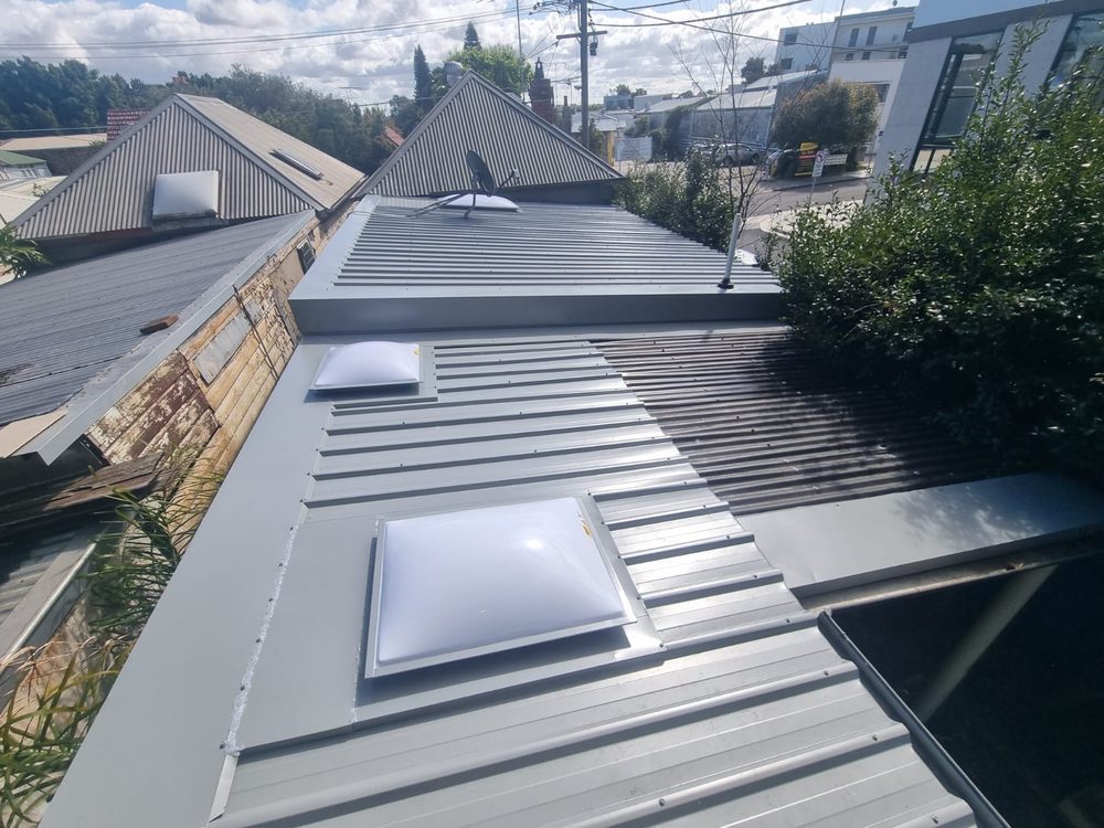 New grey standing-seam metal roof with two skylights