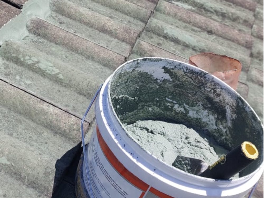 Pointing compound ready on a tiled roof ridge during a restoration