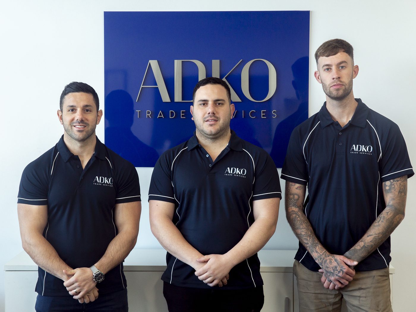 The ADKO team in uniform in front of the ADKO sign